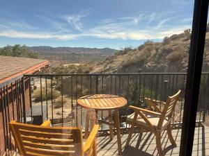 a table and chairs on a balcony with a view at Mountainside Retreat in Yucca Valley
