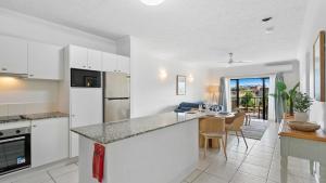 cocina con electrodomésticos blancos y comedor en Urban Getaway on Grafton, en Cairns