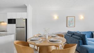 Una cocina y una sala de estar con una mesa y un sofá azul. en Urban Getaway on Grafton, en Cairns