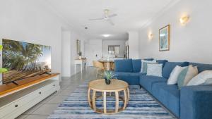 Una sala de estar con un sofá azul y una mesa. en Urban Getaway on Grafton, en Cairns