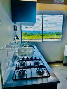 a kitchen stove with a dish basket on top of it at Apto con vista increible piscina a 10 min del Parque del Cafe in Montenegro