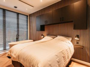 una camera da letto con un grande letto bianco e una vasca di Stylish Holiday Home with Garden Space ad Aalst