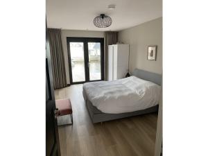 a bedroom with a bed and a refrigerator at by the water in Friesland NI in Stavoren