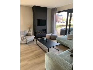 a living room with two couches and a tv at by the water in Friesland NI in Stavoren