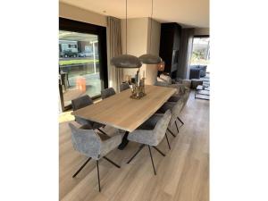 a dining room with a wooden table and chairs at by the water in Friesland NI in Stavoren