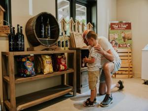 a man and a young boy looking at a shelf of food at Luxury Family Tent with Play Area in Balkbrug