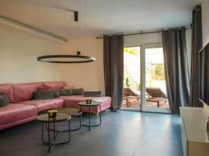 un soggiorno con divano rosa e tavoli di Magic Look with whirlpool and sauna a Donji Proložac