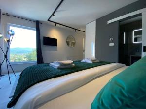 una camera da letto con un letto grande con una grande finestra di Magic Look with whirlpool and sauna a Donji Proložac Altre 26 foto