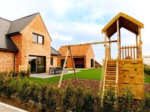 a playground in the backyard of a house at Luxury holiday home in Zwevezele in Lichtervelde