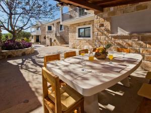 a large white table with chairs and wine glasses at Villa in Bogomolje with swimming pool in Bogomolje