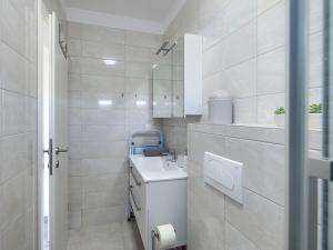 a white bathroom with a sink and a mirror at Apartment Excellence in Pula +24 photos