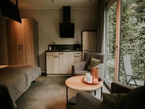 a room with a bed and a table and a kitchen at Luxury Holiday Loft in Si-Es-An in Balkbrug