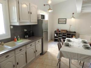 a kitchen with a table and a sink and a refrigerator at Authentic Holiday Home with Charm in Marcoux