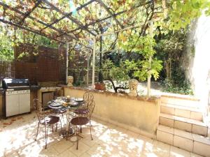 a patio with a table and chairs and a kitchen at Authentic Holiday Home with Charm in Marcoux +6 photos