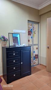 a room with a dresser with a mirror and a door at ARIAN GOLDSAND SEAVIEW APARMENT glory beach resort in Port Dickson