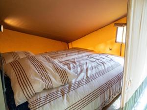 a bed in a small room with yellow walls at Luxury holiday home in Overijssel in Balkbrug