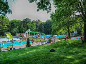 a large playground with people in a park at Charming 5-Person Bee Lodge in the Woods in Balkbrug