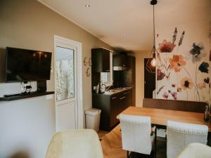 a kitchen and dining room with a table and chairs at Charming 5-Person Bee Lodge in the Woods in Balkbrug