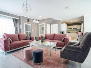 een woonkamer met roze banken en een tafel bij Victoria with pool in Imotski in Ujevići