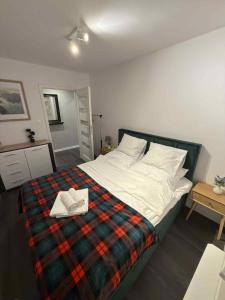 ein Schlafzimmer mit einem Bett mit einer karierten Decke in der Unterkunft Trzy pokojowe mieszkanie przy UMK ,kilka przystanków od starego Miasta in Toruń