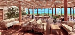 a patio with tables and chairs and the ocean at Windward Mayreau Resort in Mayreau