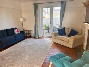 ein Wohnzimmer mit Sofa und blauem Sofa in der Unterkunft 3 bedroom Family home in Budleigh Salterton, Devon in Budleigh Salterton