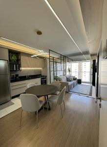een woonkamer met een tafel, stoelen en een bank bij Apartamento Novo no Melhor Bairro de Londrina in Londrina