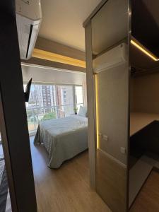 een slaapkamer met een bed en een groot raam bij Apartamento Novo no Melhor Bairro de Londrina in Londrina