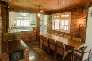 a dining room with a wooden table and a stove at Maison Valle in Taquara