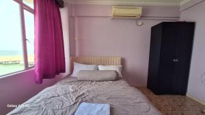 a small bed in a room with a window at ARIAN GOLDSAND SEAVIEW APARMENT glory beach resort in Port Dickson