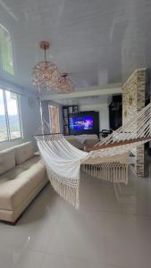 a swinging hammock in a living room with a couch at Espectacular apartamento en Guaduas in Guaduas