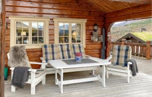 a porch with a table and chairs on a cabin at 3 Bedroom Beautiful Home In Straumgjerde in Brunstad +10 photos