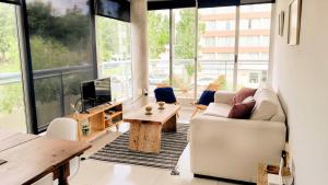 a living room with a couch and a table at Apto 210 Un Refugio luminoso frente a la playa in Colonia del Sacramento