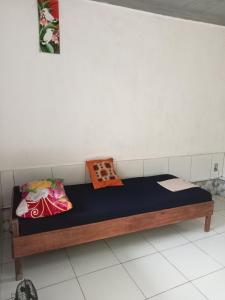 a bed in a room with two pillows on it at ATB Hostel in Lovina