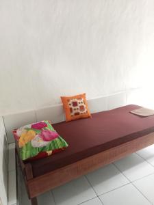 a bench with two pillows on it in a room at ATB Hostel in Lovina +8 photos