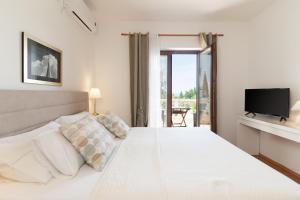 een slaapkamer met een wit bed en een televisie bij Apartments with parking space Muline, Ugljan - 8521 in Donje Selo
