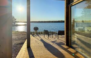 a porch with a view of a lake with chairs at Gorgeous Home In Bolmsö With Lake View in Bolmsö