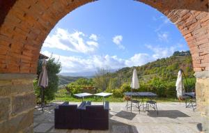 an archway with tables and umbrellas on a patio at Awesome Apartment In Bibbiena in Serravalle +16 photos