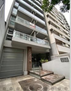 un edificio de apartamentos con un garaje delante de él en Las Lomitas Torre London, en Lomas de Zamora