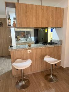 een keuken met twee witte krukken voor een aanrecht bij Apartment, 3 bedrooms and 2 full bathrooms in Armenia