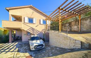 a small white car parked in front of a house at Cozy Apartment In Vrbnik in Vrbnik +10 photos