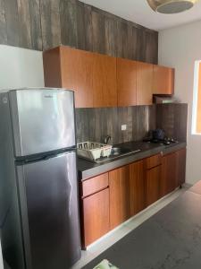 a kitchen with a stainless steel refrigerator and wooden cabinets at Departamento 10 Polanco in Valladolid