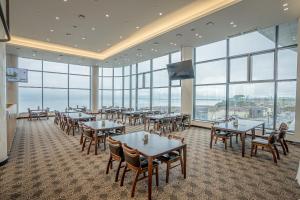 a dining room with tables and chairs and windows at Goheung Sun Valley Resort in Goheung