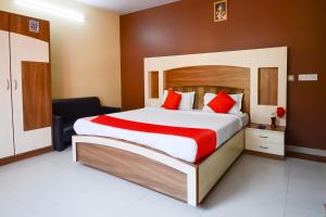 Hotel O Samar Palace في جايبور: غرفة نوم بسرير كبير مع وسائد حمراء +25 صورة