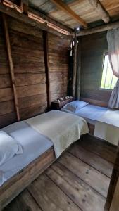 two beds in a room with wooden floors at Mi Cabañita Guest House in Playa Blanca