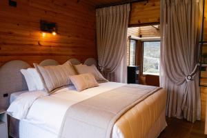a large white bed in a room with wooden walls at Vistas de Mantiqueira in Bom Jardim da Serra +76 photos