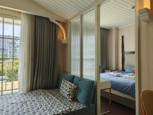 a bedroom with a bed and a large window at Grand Florida芭提雅带免费游泳池温泉桑拿浴和健身房瑜伽室私家海滩公寓E206 in Na Jomtien +60 photos