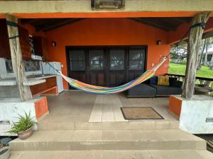 a hammock on a porch of a house at Venao Beachfront Cabana in Playa Venao