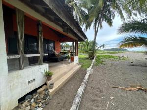 a house with a hammock on the side of it at Venao Beachfront Cabana in Playa Venao
