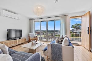 Una sala de estar con un sofá y un televisor. en Harbour Mist Hideaway - Where Coast Meets Calm, en Ulladulla